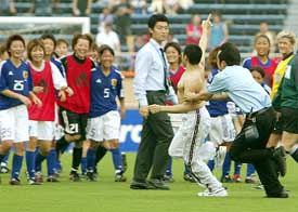 An unidentified Mexican streaker dashes across the pitch as the Japanese national womens soccer team laughs