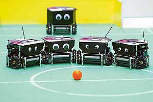  team of robots stand before the ball prior to the start of their match during the seventh Soccer World Championship for Robots in Padua, northern Italy.
