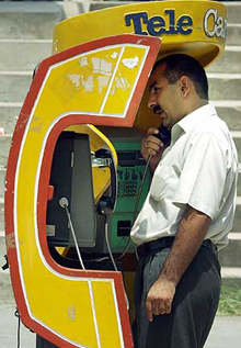 A man uses a public telephone at a shopping complex in Islamabad