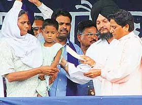 Uttar Pradesh Chief Minister Mayawati hands over a cheque for Rs 5 lakh to Ms Channi