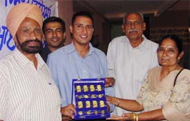 Jubilant Jasbir Singh of SAS Nagar with his parents after winning the first prize of 1 kg gold in the 23rd Lucky Coupon Scheme at a state-level function