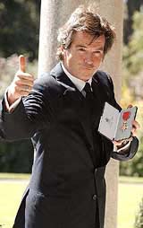 The Irish film actor Pierce Brosnan displays his honorary OBE
