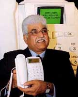 Vice-Chairman and MD of Bharti Teletech Rakesh Bharti Mittal shows a telephone instrument after launching India's first SMS solution on fixed line