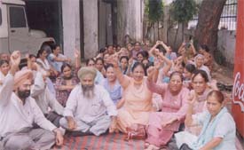 Agitated health employees who have not been paid salaries for the past six months stage a dharna at the Civil Surgeons office