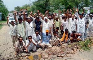 Residents of village Adhnia in Muktsar district, who jammed traffic on Fazilka-Delhi national Highway, raise slogans against the district administration 