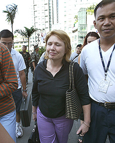 Australian Ambassador to the Philippines Ruth Pearce and other foreigners emerge from the Oakwood building