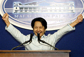 Philippine President Gloria Macapagal Arroyo raises her hands