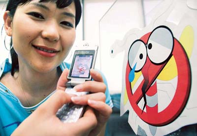A South Korean woman shows a cellphone in Seoul that is capable of repelling insects.