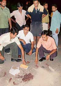Supporters of PUSU indicate stains of blood where Malwinder Singh Kang was attacked in the university market on Wednesday evening