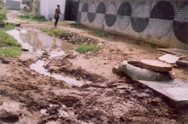 A manhole that leaks and water gets collected in open plots in Aman Nagar