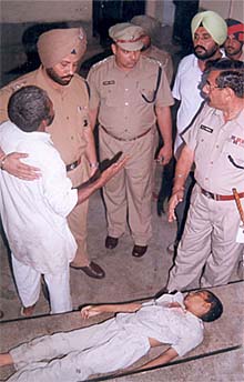 Gurpreets father Jinder Pal remonstrates with SSP P.S. Umranagal as Gurpreet lies dead on a stretcher in Patiala on Friday. 