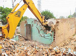 About 450 acres owned by the Chandigarh Administration have been grabbed by slum-dwellers from UP and Bihar