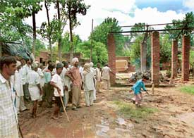 Armed with lathis and sticks, Ramdasias guard the pyre of Bagindo Devi at a cremation ground in Khellan village
