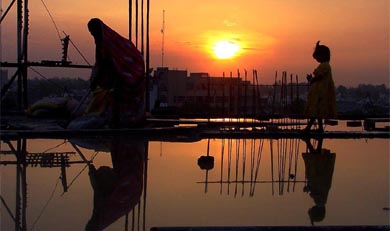 Rain paints the sky in bright hues as workers leave a construction site in Ludhiana
