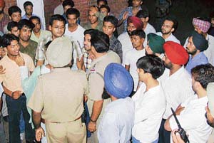 Students agitated over attack on Malwinder Singh Kang, Panjab University Students Union president, argue with policemen in front of the PGI emergency.