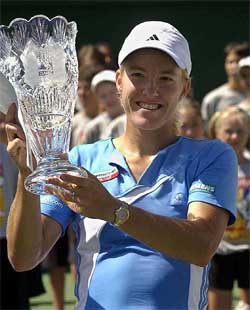 Justine Henin-Hardenne of Belgium lifts the winners trophy after defeating compatriot Kim Clijsters in the finals of the Acura Classic