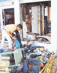 A shopkeeper in Sector 17 removes burnt clothes from his shop which caught fire on Tuesday