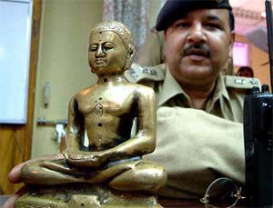 A police officer shows a 200-year-old statue of Lord Mahavir
