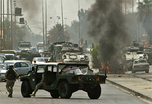A US Army vehicle burns in the middle of a street in Baghdad