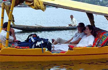 Foreign tourists enjoy a ride on a Shikara at Dal Lake in Srinagar 