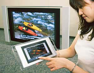 A Sony employee demonstrates a newly developed 42-inch wide screen Plasma flat panel television KDE-P42HZ1 with a wireless controlled seven-inch liquid crystal display (LCD) palette display in Tokyo.