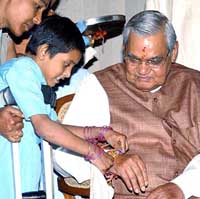 A handicapped girl ties a rakhi on  Prime Minister Atal Bihari Vajpayee's wrist