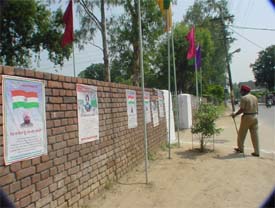 Posters of the Chief Minister and a martyr pasted on a wall of Government College for Boys