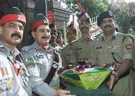 Pakistans Brigadier Sahi Marjan presents sweets to Indian battalion commander D. K. Sharma to mark Pakistans 56th independence day celebrations