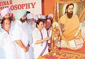 The general secretary of All India Congress Committee, lighting the lamp at the 8th international seminar on Sri Guru Ravidas held at Law Auditorium, Panjab University, in Chandigarh on Saturday. Also seen in the picture are president, PCC, Mr Hans Pal, Punjab CM Amarinder Singh and president of the Guru Ravidas Foundation India, Mr Jagjit Singh.