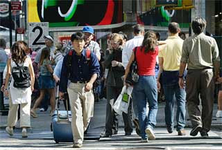 People pass under electronic signs in Times Square in New York 