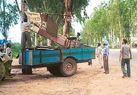 The enforcement team of the Punjab Forest Department pulls down a hoarding nailed to trees in violation of the Forest Conservation Act along the Chandigarh-Ambala highway at Dappar village
