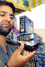 A shopkeeper displays a mobile phone