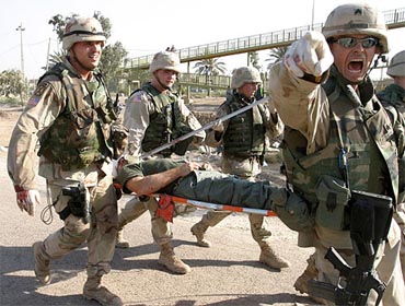 A US soldier screams while carrying an injured person