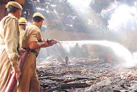Firemen trying to douse the blaze at Vivek cinema in Patel Nagar