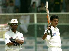Pakistani batsman Yasir Hameed waves his bat to acknowledge the cheering crowd after scoring his second hundred 