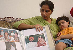 Dr Navjot Kaur (PhD), daughter-in-law of sitting Akali MLA, Mr Vir Singh Lopoke, with her two-and- half-years-old daughter. Navjot Kaur who was allegedly beaten up by Mr Lopoke and her husband, shows the album of her marriage, solemnised in 2000. The album contains pictures of Mr Lopoke and senior Akali leader Mr Ranjit Singh Brahmpura.