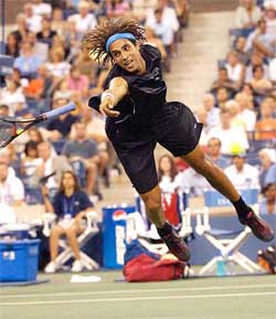 James Blake of the USA loses his racket while diving for a volley at the net in his match against Mariano Zabaleta 