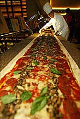 A Chinese chef prepares a 20-metre-long pizza