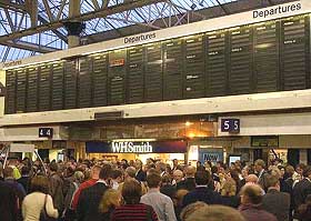 Commuters at Waterloo railway station in Central London look up at blank departure boards 