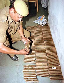 A police officer examining the gelatine sticks seized from an abandoned bag at the New Delhi Railway Station
