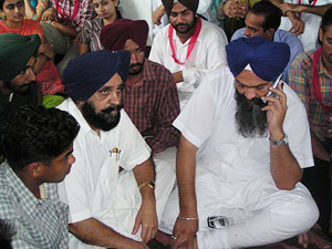 Akali leader Prem Singh Chandumajra sits with protesting students on the Punjabi University campus