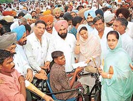 Ms Praneet Kaur, MP, grants financial help to a physically challenged person at a function in Dera Bassi