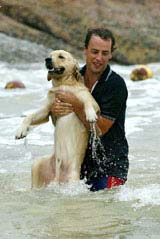 A man saves a dog from drowning at a beach as Dujuan typhoon hit Hong Kong 