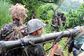 Army jawans take up positions near a forest at Ghatti in Jammu on Wednesday during an encounter with militants.