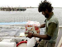 An Indian fisherman holds a gift presented to him by the Pakistani authorities before his repatriation at Karachi harbour 