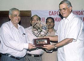 Delhi Lt-Governor receiving the Capital Foundation Society Memento from Surinder Anand in the Capital