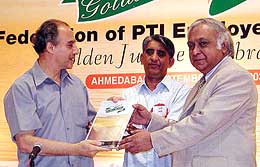 Union Minister for Communication and Information Technology Arun Shourie and ONGC chairman Subir Raha show a souvenir at the golden jubilee celebrations of Federation of PTI Employees Union