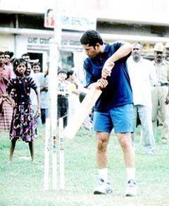 Sachin Tendulkar plays cricket with a group of slum children