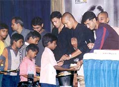 Indian cricket captain Saurav Ganguly, Murali Karthik, Ajit Agarkar and Parthiv Patel serve dinner to slum children