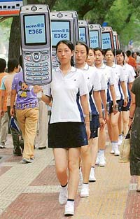 Chinese models parade with paper cutouts of mobile phones during a promotional gala in Xian, the capital of Chinas Shaanxi province.